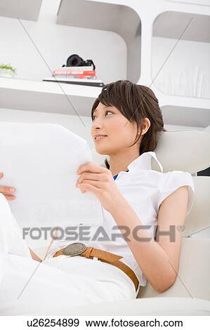 Stock Photo - A young woman reading document. Fotosearch