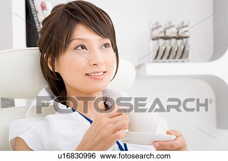 Stock Photograph - A young woman resting on sofa. Fotosearch