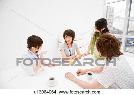 Picture - Four people meeting at table. Fotosearch