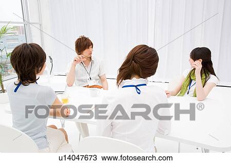 Four people meeting at table View Large Photo Image Stock Image - Four people meeting at table. Fotosearch