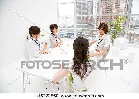 Four people meeting at table View Large Photo Image Stock Image - Four people meeting at table. Fotosearch