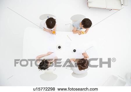 Four people meeting at table View Large Photo Image Stock Photo - Four people meeting at table. Fotosearch