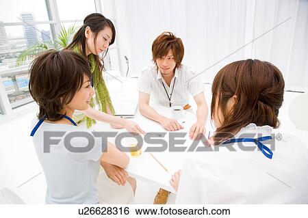 Four people meeting at table View Large Photo Image Stock Photograph - Four people meeting at table. Fotosearch