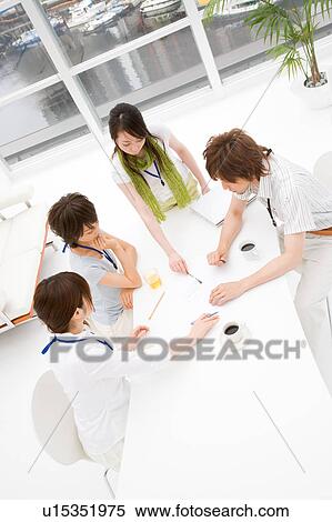Stock Photography - Four people meeting at table. Fotosearch