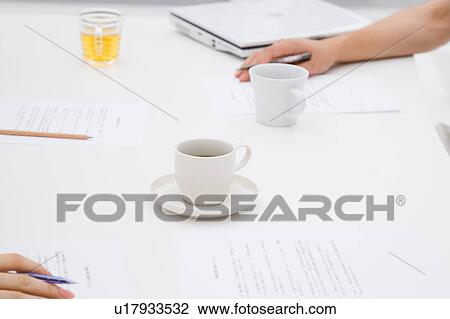 Stock Image - People's hands on meeting table. Fotosearch
