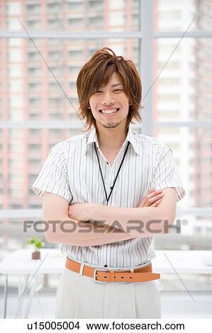 Picture - Portrait of young man standing in office. Fotosearch