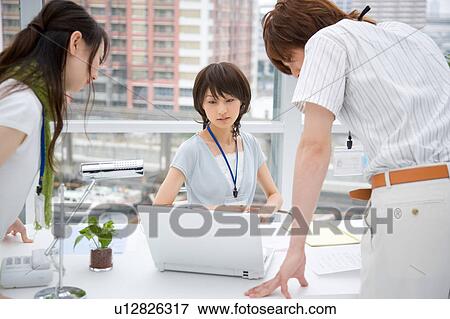 Stock Photo - Three people looking at computer. Fotosearch