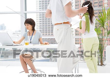 Three young people working in office View Large Photo Image Stock Image - Three young people working in office. Fotosearch