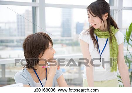 Stock Photograph - Two young women talking. Fotosearch