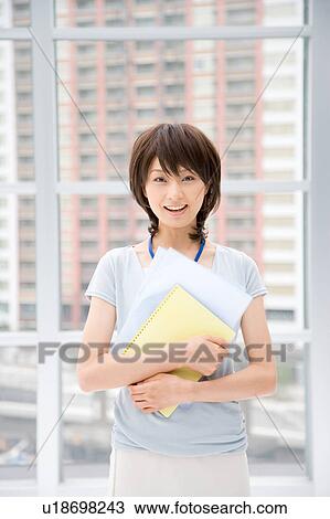 Young woman holding files View Large Photo Image Stock Image - Young woman holding files. Fotosearch