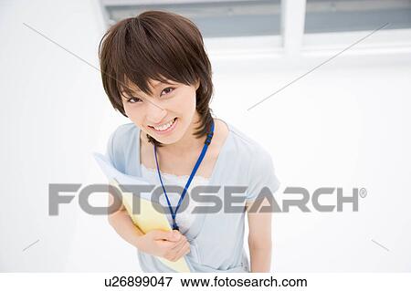 Young woman holding files View Large Photo Image Stock Photo - Young woman holding files. Fotosearch