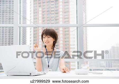 Stock Photo - Young woman looking at computer monitor. Fotosearch