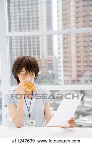 Young woman looking at document View Large Photo Image Stock Photo - Young woman looking at document. Fotosearch