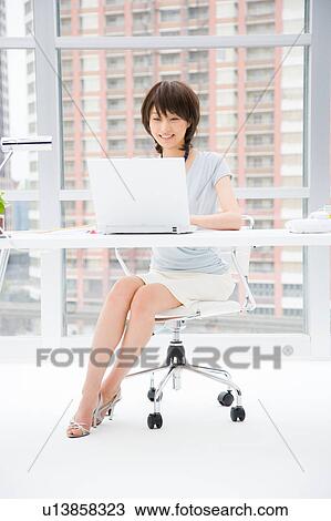 Young woman working at her desk View Large Photo Image Stock Image - Young woman working at her desk. Fotosearch