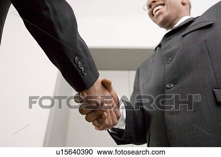 Stock Image - Businessmen shaking hands. Fotosearch