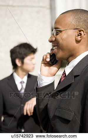 Businessmen using mobile phone View Large Photo Image Stock Image - Businessmen using mobile phone. Fotosearch