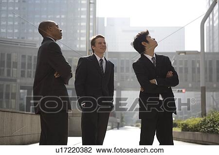 Stock Image - Three businessmen looking up. Fotosearch