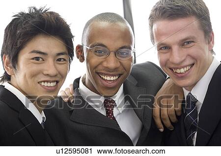 Stock Image - Three businessmen smiling looking at camera. Fotosearch