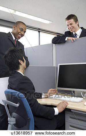 Stock Photo - Three businessmen talking in office. Fotosearch