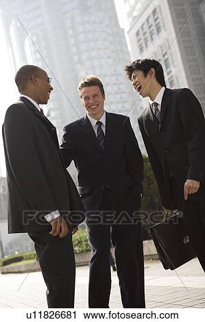 Stock Image - Three businessmen talking. Fotosearch