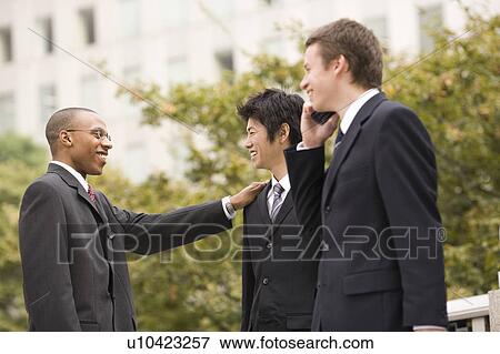 Stock Photo - Three businessmen talking. Fotosearch