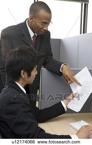 Stock Photo - Two businessmen looking at documents. Fotosearch