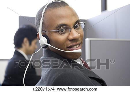 Picture - Young man working in call center. Fotosearch