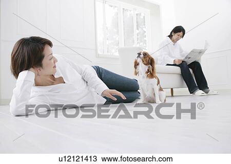 Stock Image - Young couple and cavalier king Charles spaniel. Fotosearch