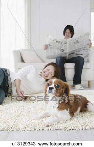 Stock Image - Young couple and cavalier king Charles spaniel. Fotosearch