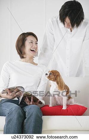 Stock Image - Young couple and cavalier king Charles spaniel. Fotosearch