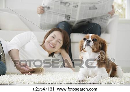 Stock Image - Young couple and cavalier king Charles spaniel. Fotosearch