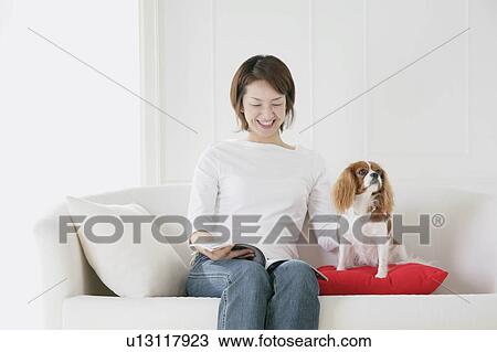 Stock Image - Young woman and cavalier king Charles spaniel. Fotosearch