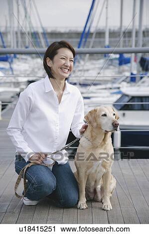 Stock Image - Young woman and Labrador retriever. Fotosearch