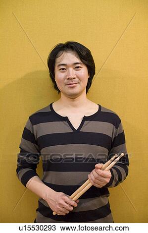 Stock Image - Young man holding drumsticks. Fotosearch