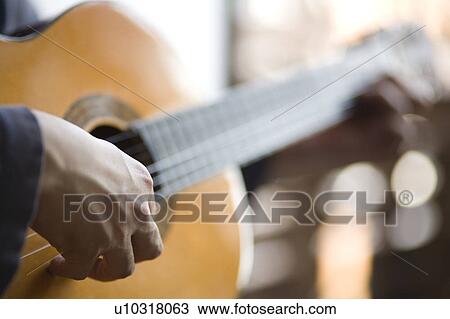 Young man playing acoustic guitar View Large Photo Image Stock Image - Young man playing acoustic guitar. Fotosearch