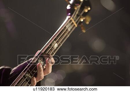 Young man playing bass guitar on stage View Large Photo Image Stock Image - Young man playing bass guitar on stage. Fotosearch