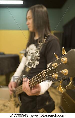 Young man playing bass guitar View Large Photo Image Stock Image - Young man playing bass guitar. Fotosearch