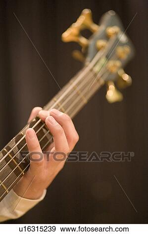 Stock Photo - Young man playing bass guitar. Fotosearch