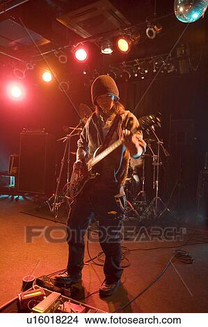 Young man playing electric guitar on stage View Large Photo Image Picture - Young man playing electric guitar on stage. Fotosearch