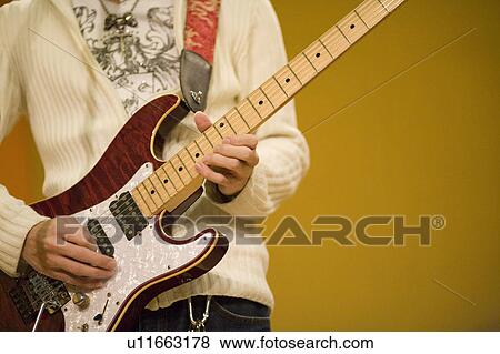 Young man playing electric guitar View Large Photo Image Stock Photo - Young man playing electric guitar. Fotosearch