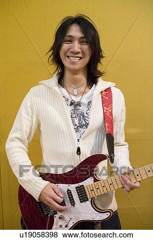 Stock Photo - Young man playing electric guitar. Fotosearch