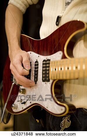 Young man playing electric guitar View Large Photo Image Stock Photo - Young man playing electric guitar. Fotosearch