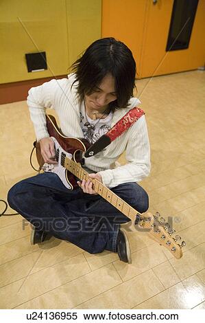 Young man playing electric guitar View Large Photo Image Stock Photography - Young man playing electric guitar. Fotosearch
