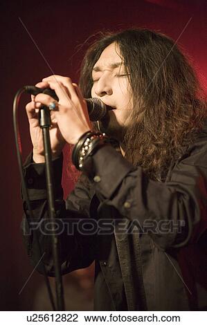 Stock Image - Young man singing on stage. Fotosearch