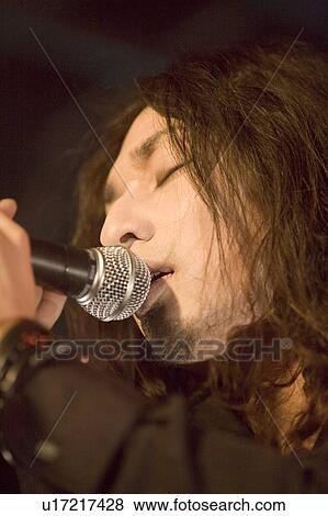 Stock Photo - Young man singing on stage. Fotosearch