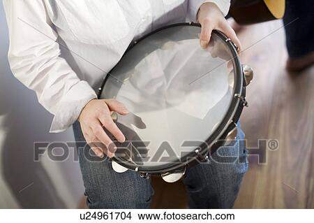 Young woman playing tambourine View Large Photo Image Picture - Young woman playing tambourine. Fotosearch