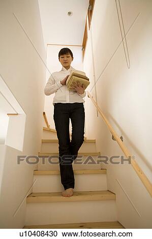 Stock Image - Young woman carrying towels. Fotosearch
