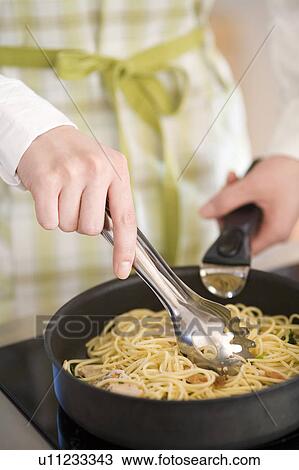 Young woman cooking spaghetti View Large Photo Image Stock Image - Young woman cooking spaghetti. Fotosearch