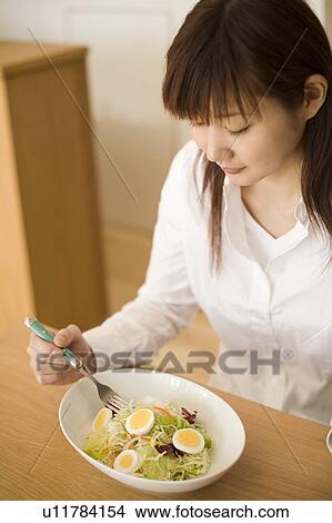 Young woman eating salad View Large Photo Image Picture - Young woman eating salad. Fotosearch
