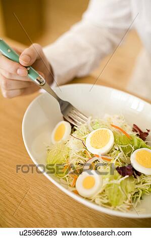 Stock Photo - Young woman eating salad. Fotosearch
